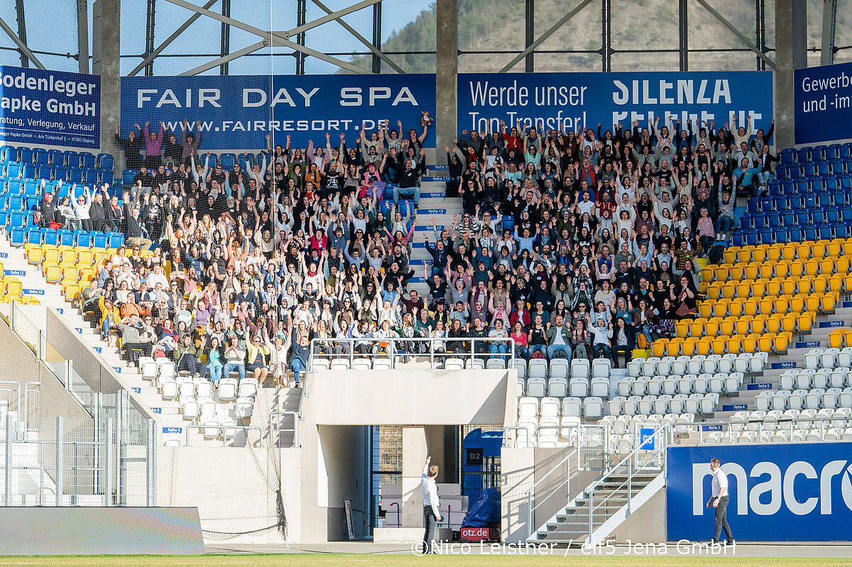 Mitarbeitendenfachtag 2026 in Jena Mitarbeiter der TSA stehen unter Anzeigetafel der adhoc-Arena in Jena