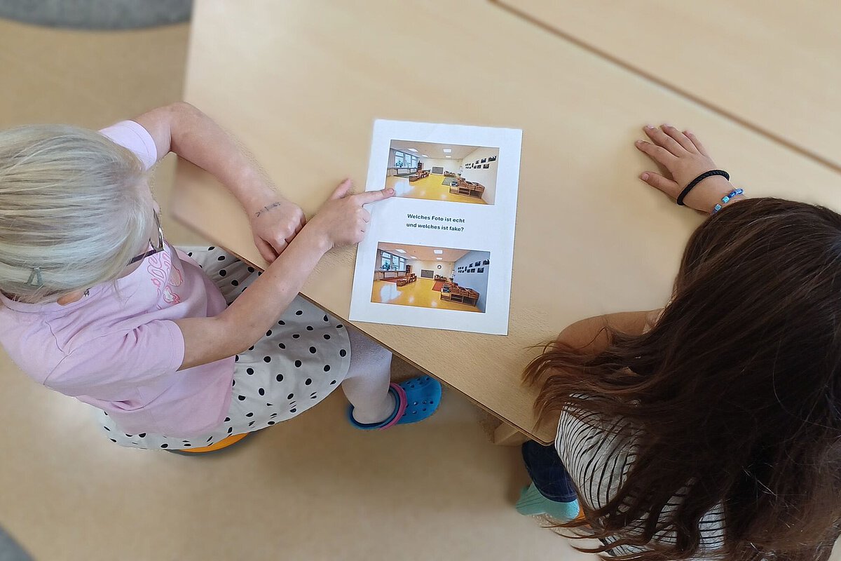 Kinder lernen KI verstehen: Echte und künstlich erzeugte Bilder vergleichen Kinder betrachten im Hort Hermsdorfein Arbeitsblatt und vergleichen echte mit KI-generierten Fotos, um den Umgang mit Künstlicher Intelligenz zu lernen.