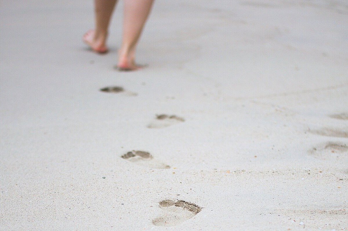 Fußspuren im Sand Person hinterlässt Fußspuren im Sand und entfernt sich aus dem Bild.