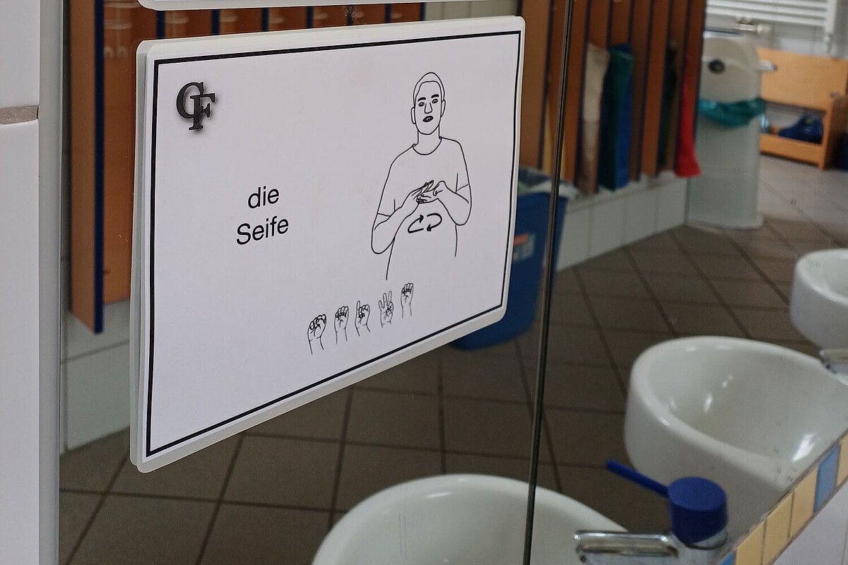 Gebärdenkarten unterstützen Orientierung im Kita-Alltag Gebärden-Bildkarten für „Spiegel“ und „Seife“ an einem Badezimmerspiegel im Waldkindergarten Ottendorf-Okrilla